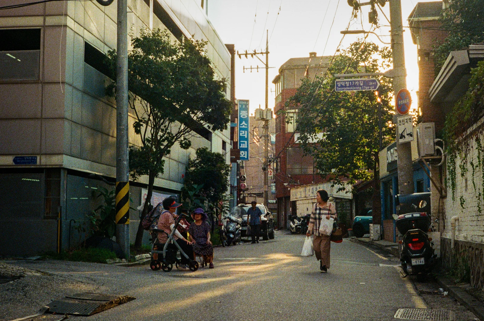 Two women walking through a quiet neighborhood street